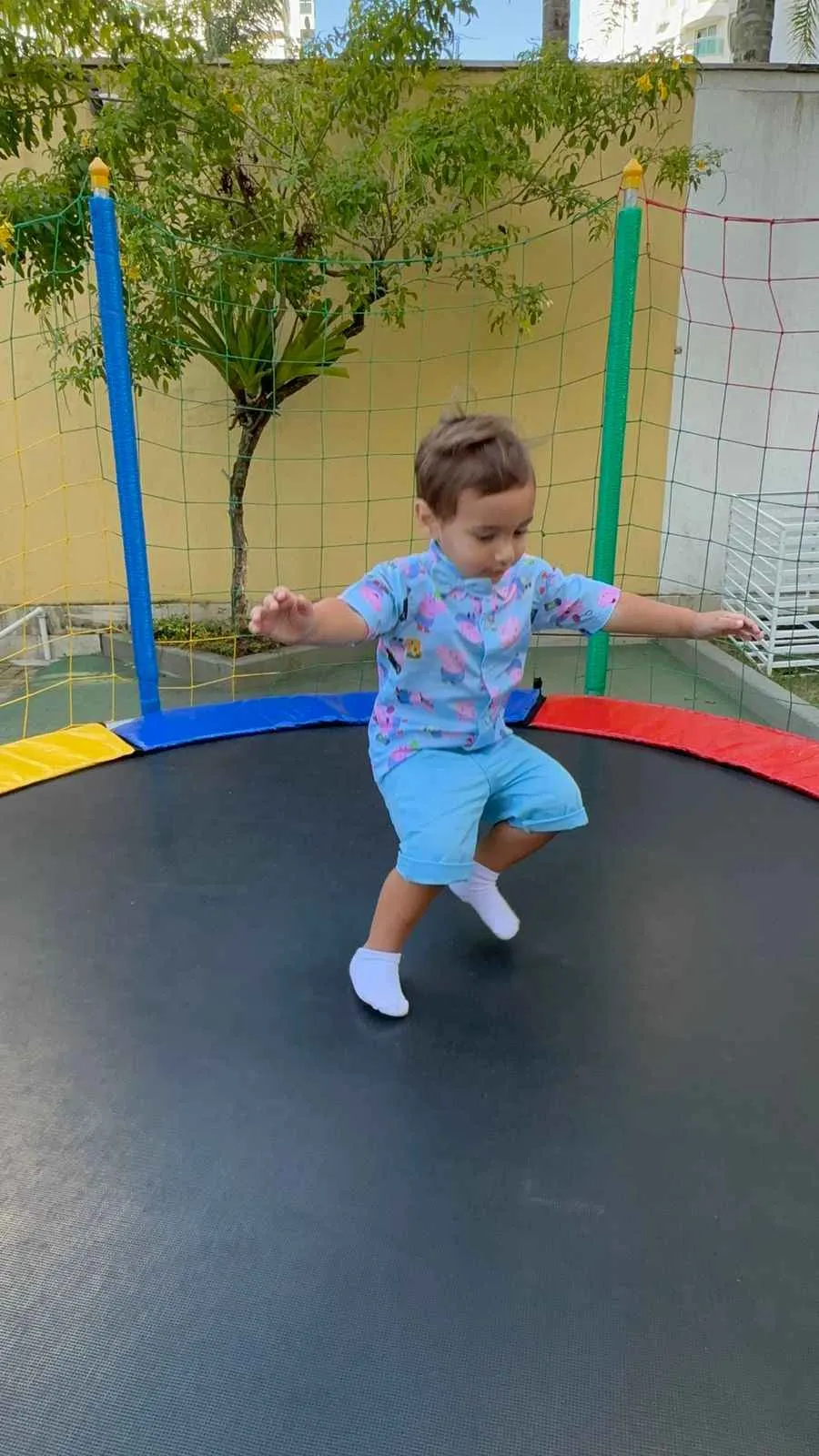 Criança pulando em cama elástica