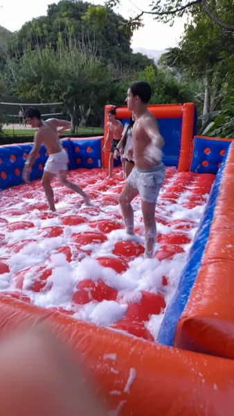 Crianças disputando partida de futebol de sabão em festa de aniversário no Rio de Janeiro